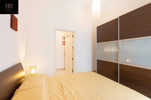 2 habitaciones, escritorio y tabla de planchar con plancha