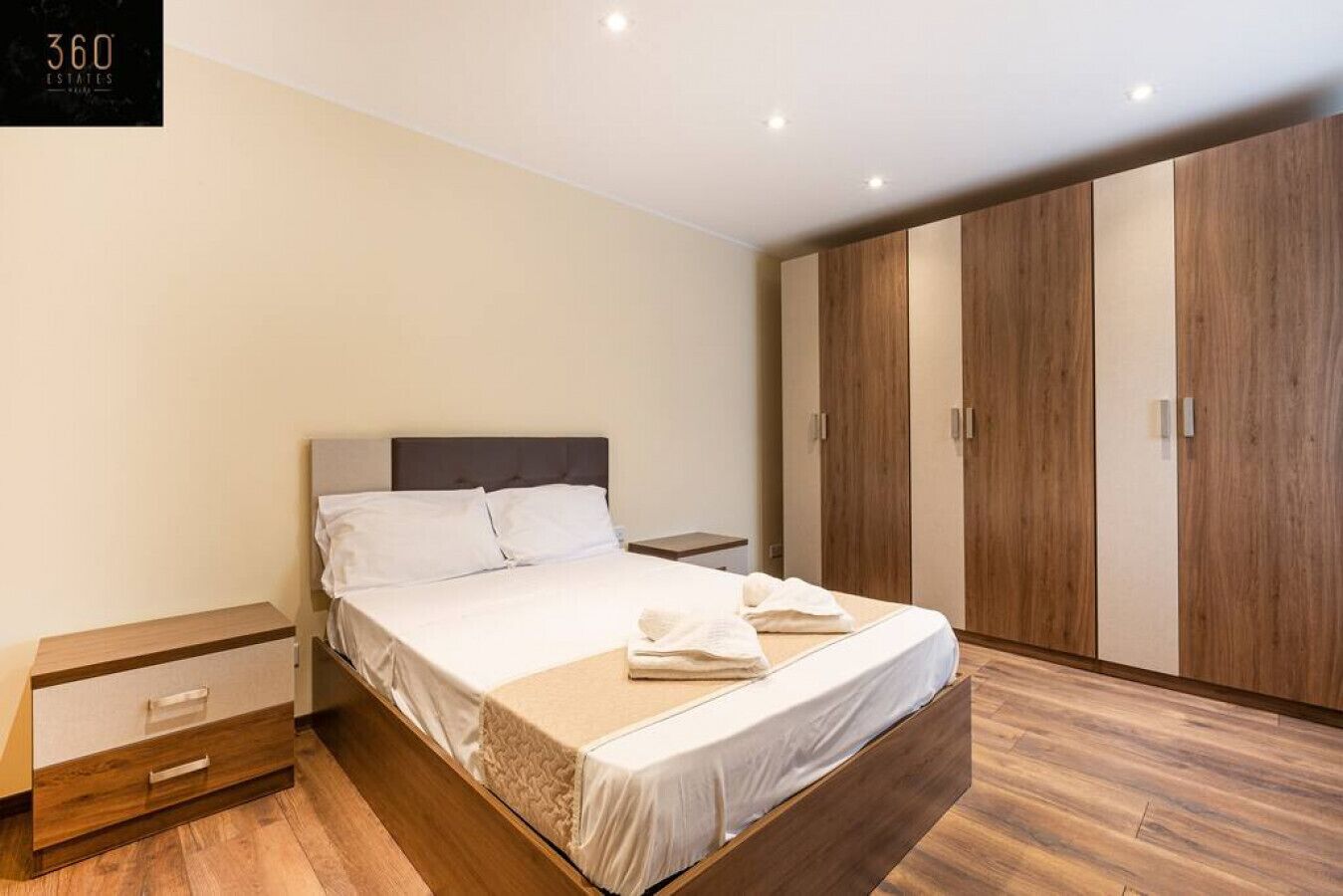 Une chambre à coucher moderne avec un lit, une armoire en bois et une table de chevet.