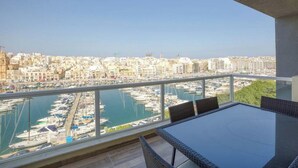 Ein Balkon mit Blick auf einen Hafen und die Skyline der Stadt.