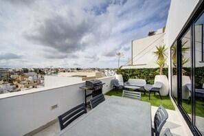 A rooftop terrace with a barbecue, seating area, and a view of the cityscape. - Penthouse + BBQ Kitchen Island & Massive living (San Ġiljan)