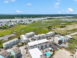 Een kusthotel met meerdere gebouwen, een zwembad en uitzicht op zee en groen.