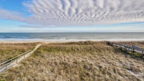 A beach with a wooden boardwalk and a path leading to the water. - Island Treasure, CB Oceanfront Retreat (Carolina Beach)