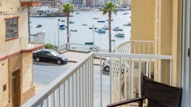 A balcony with a view of a marina and buildings.