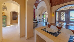 A spacious interior with high ceilings, arched doorways, and a dining area with a view. - VESTA - Superior Villa - 3BR - North Golf I (Hurghada)