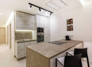 A modern kitchen with a central island, built-in appliances, and minimalist decor.