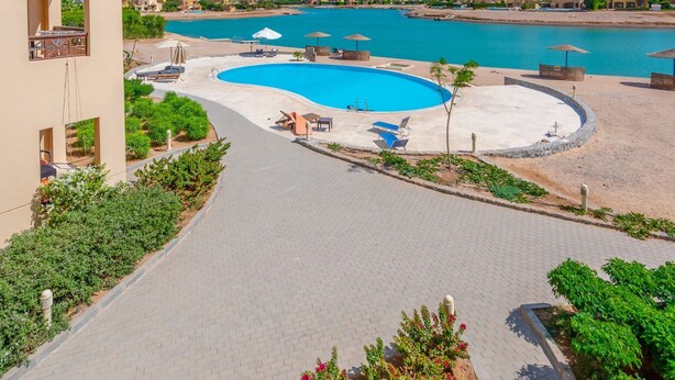 Un complexe hôtelier doté d’une piscine, d’un patio couvert et offrant une vue sur la mer.