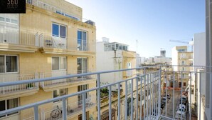 A multi-story residential building with balconies, a clear sky, and construction cranes in the background. - Brand new central APT with strong WIFI & Comfy Bed (Il-Gżira)