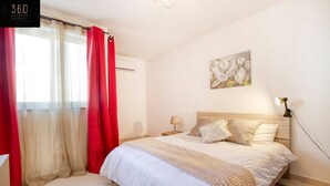 Una camera da letto con un letto, un comodino, una lampada e un quadro appeso al muro.