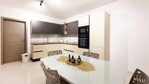 Una cucina moderna con pensili scuri, un piano di lavoro bianco e un forno a incasso.