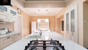 A modern kitchen with a central island, double sink, and a gas stove. - Spacious NUM1 house in Swieqi - Sleeps 18 w/WIFI (Is-Swieqi)