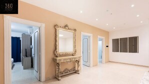 A hallway with a large ornate mirror, doors leading to rooms, and a sign for 360 Estates. - Spacious NUM1 house in Swieqi - Sleeps 18 w/WIFI (Is-Swieqi)