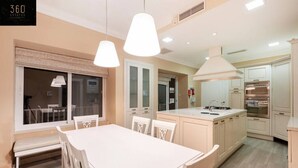 A modern kitchen with white cabinetry, a central island, and pendant lighting. - Spacious NUM1 house in Swieqi - Sleeps 18 w/WIFI (Is-Swieqi)