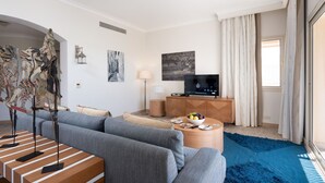 Ein modernes Wohnzimmer mit einer Couch, einem Couchtisch und einem Flachbildfernseher.