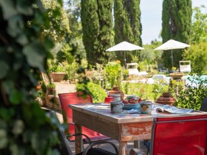 An outdoor seating area with tables and chairs, surrounded by greenery and trees. - La Colonica by Interhome (Gambassi Terme)