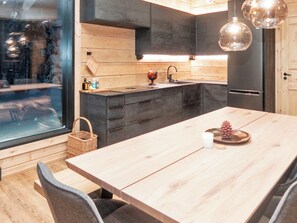 Une cuisine moderne avec des meubles en bois, un îlot central et des luminaires suspendus.