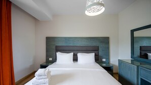 A hotel room with a large bed, two bedside tables, a nightstand, a dresser, and a mirror. - VESTA - Luxury apt - 2BR - CFC (II) (New Cairo City)