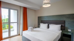 A modern bedroom with a large bed, a nightstand, a glass door leading to a balcony, and a ceiling light fixture. - VESTA - Luxury apt - 2BR - CFC (II) (New Cairo City)