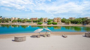 A resort with a swimming pool, sun loungers, and a clear view of the surrounding buildings.