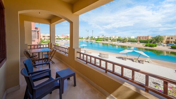 A balcony with a view of a swimming pool and beach.