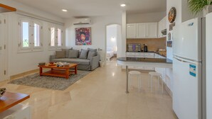 A modern apartment with a living room, kitchen, and dining area.