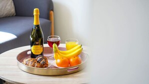 A tray with a bottle of Prosecco, croissants, bananas, oranges, and a glass of red wine. - Beautiful Apartment • Close to Town Centre • Free Parking • Fast-Wifi • Sky TV • By Yoko Property (Northampton)