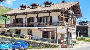 Un hotel para ciclistas en familia con un balcón, un cartel que indica que es hotel para ciclistas y vistas del entorno.