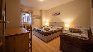 A bedroom with a bed, a desk, and a chair. - You'll have everything at your fingertips by staying at Quadrilocale Aprica! (Livigno)