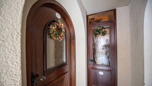 Eine Holztür mit Fenster und einem Kranz.