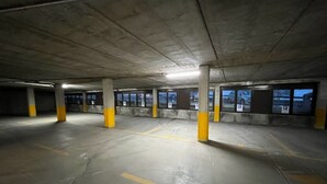 An underground parking garage with concrete pillars and yellow markings on the floor. - Residence Livigno is waiting for you to have an unforgettable experience! (Livigno)