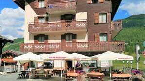 A multi-story wooden building with outdoor seating and a sign for "Birra Moretti". - Residence Livigno is waiting for you to have an unforgettable experience! (Livigno)