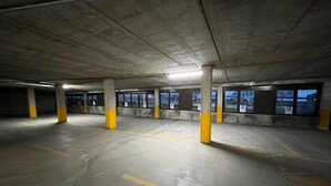 An underground parking garage with concrete pillars and yellow markings on the floor. - Autonomy, but also comfort? Residence Livigno is the one for you! (Livigno)