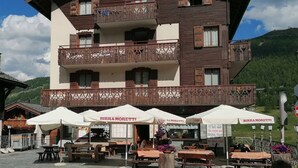 A multi-story building with outdoor seating and a sign for "Birra Moretti." - Simple, yet traditional. The two-room apartment at Residence Livigno will leave (Livigno)