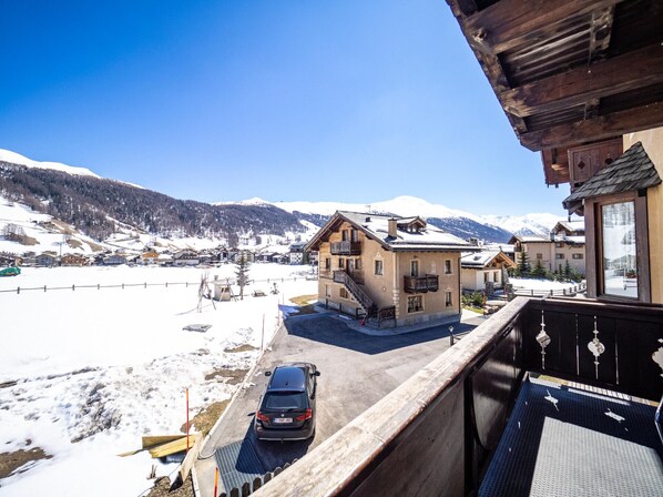Un hôtel doté d’un balcon donnant sur un paysage enneigé et des montagnes.