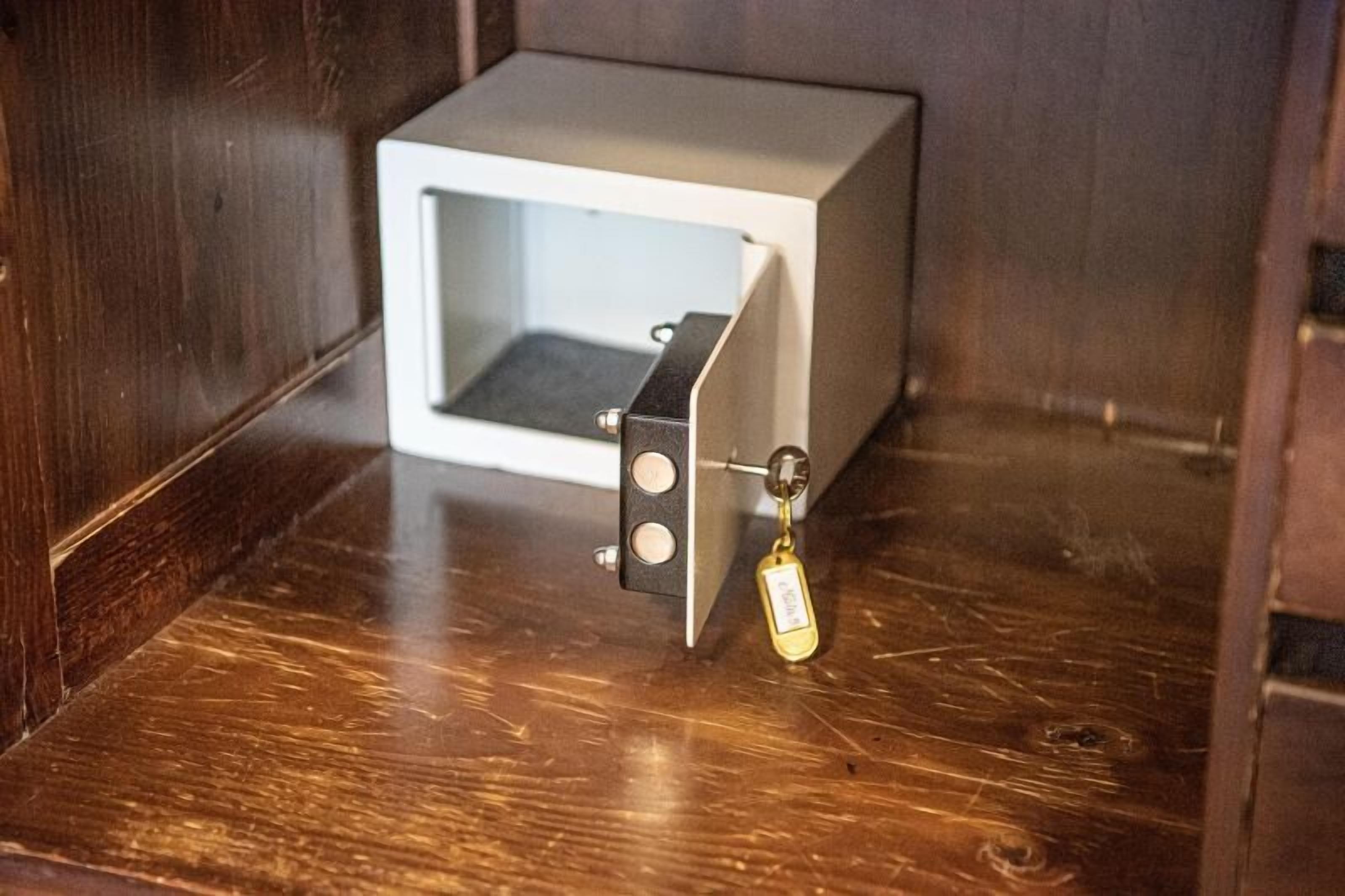 A small, white, square-shaped object with a key attached, placed on a wooden floor.