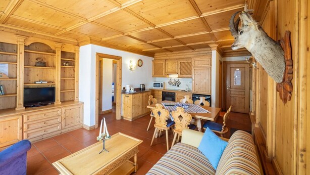Un intérieur en bois avec un téléviseur, une table à manger et un canapé.