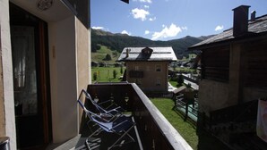 Un balcon avec vue sur un village et des montagnes.