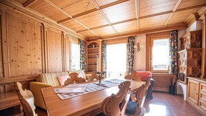 Un intérieur en bois comprenant une table à manger, des chaises, un canapé et une bibliothèque.