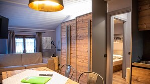Ein modernes Zimmer mit einem Holztisch, einer Couch und einem Bett.