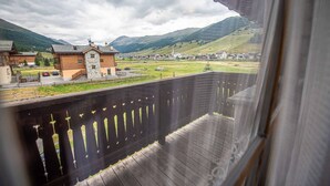 Un balcon avec vue sur un village, une église et des montagnes.