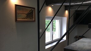 Portaikko, josta avautuu näkymä ikkunaan ja seinällä on taulu.