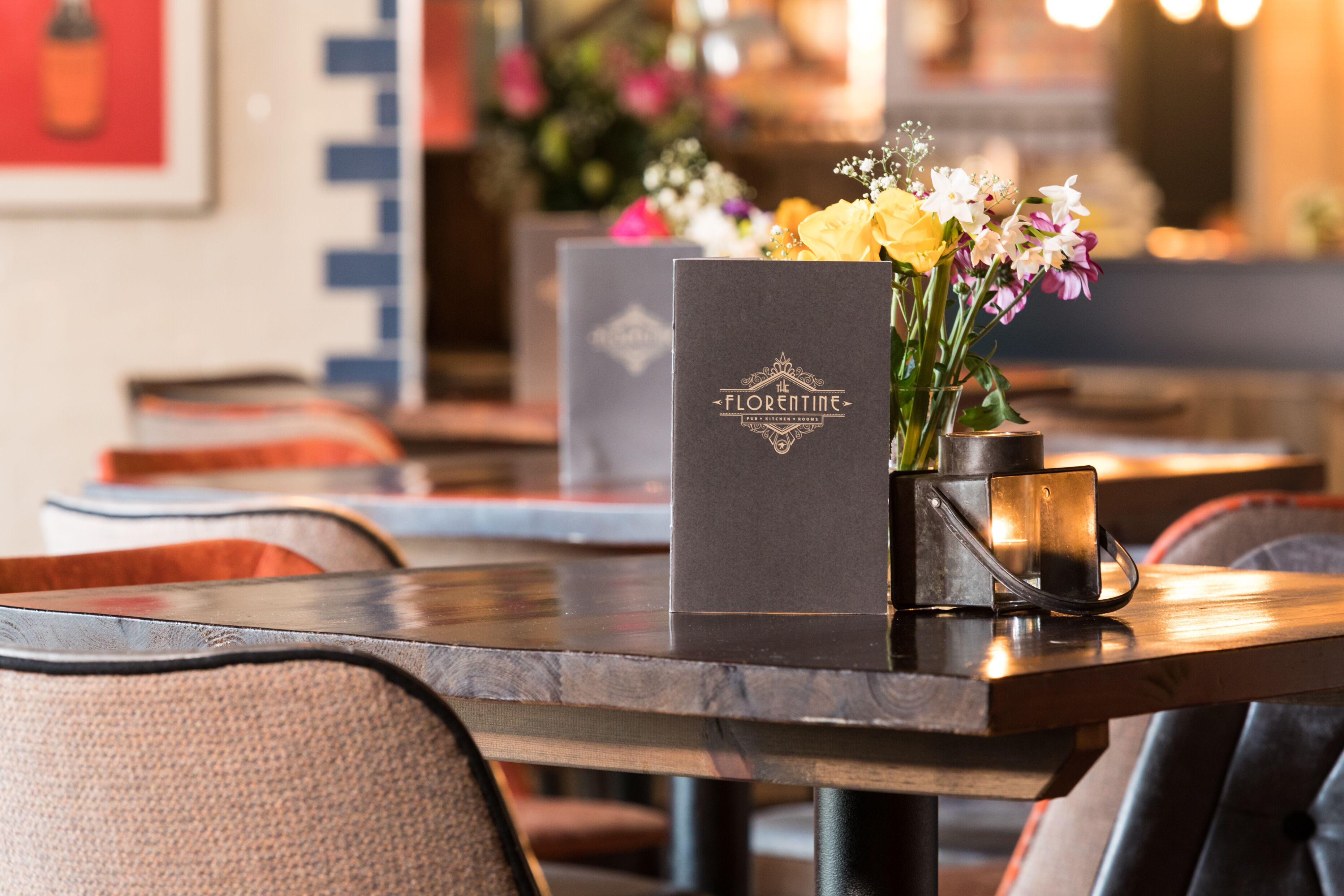 A table with a black Florentine menu box and a vase of flowers.