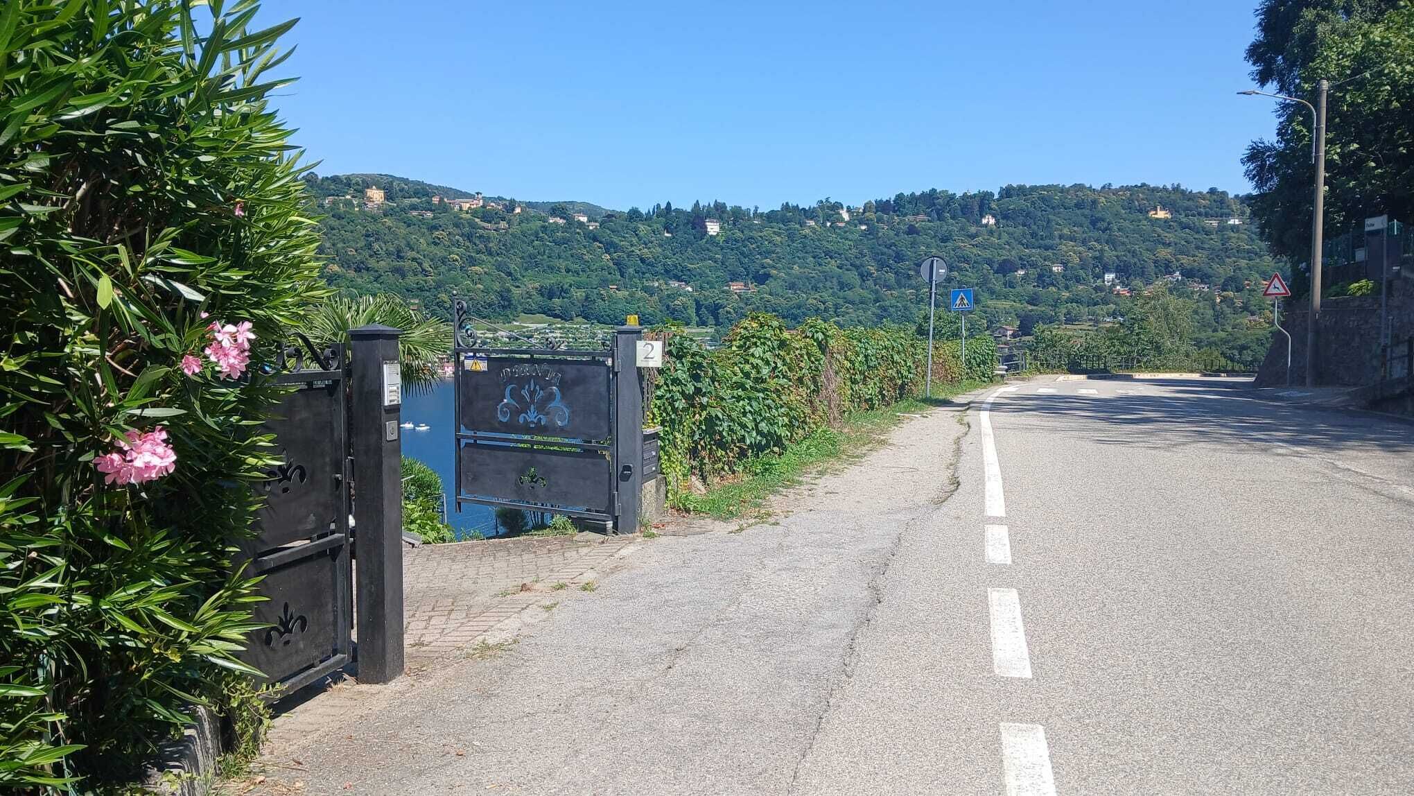 Eine gepflasterte Straße mit einem Tor und einem Schild, das auf einen Fußgängerüberweg hinweist.