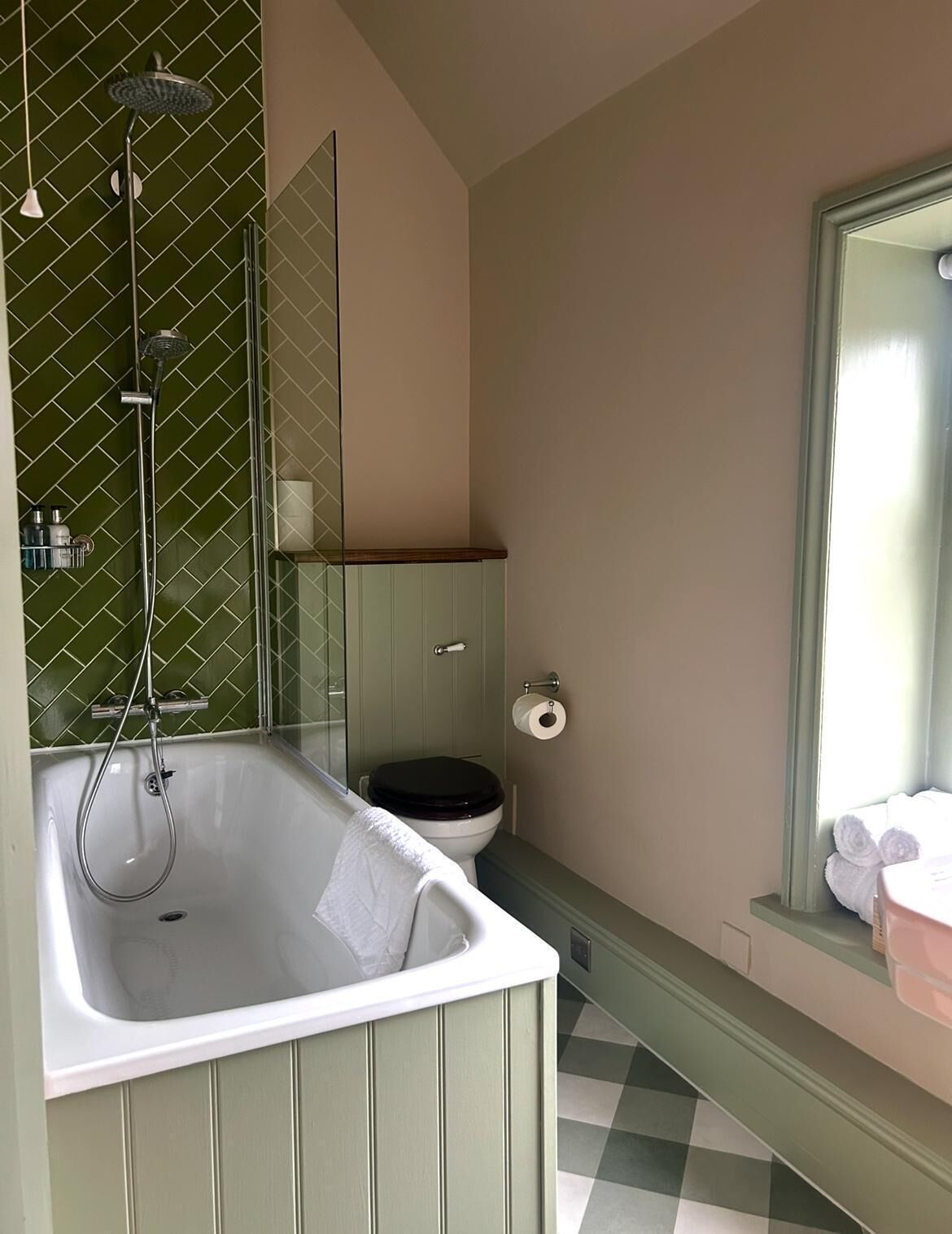 Ein Badezimmer mit freistehender Badewanne, Toilette und einem großen Spiegel.
