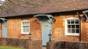 A traditional brick building with two doors labeled "Ruby" and "Quail". - Huntsman of Brockenhurst (Brockenhurst)