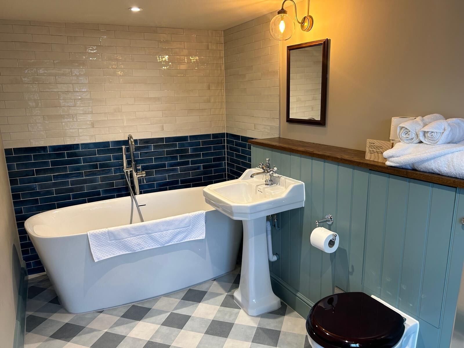 A bathroom with a freestanding bathtub, a pedestal sink, and a toilet.