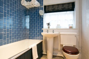 A bathroom with a bathtub, sink, and toilet. - Huntsman of Brockenhurst (Brockenhurst)