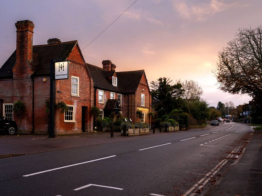 A traditional brick building with a sign for 'The Huntsman' pub.