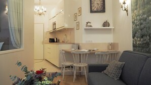 A compact living space with a kitchenette, a dining area, and a sofa. - Louvre Opera Design (Paris)