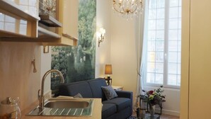 A modern kitchen with a built-in sink, a chandelier, and a large window. - Louvre Opera Design (Paris)