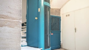 A hallway with a blue door, a white door, and a white wall.